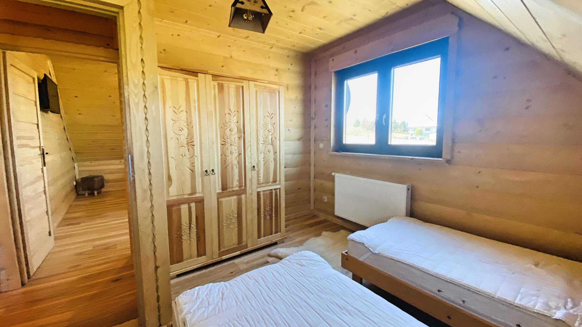 Luksusowy salon z kominkiem i tarasem w domu z bali w Trybszu