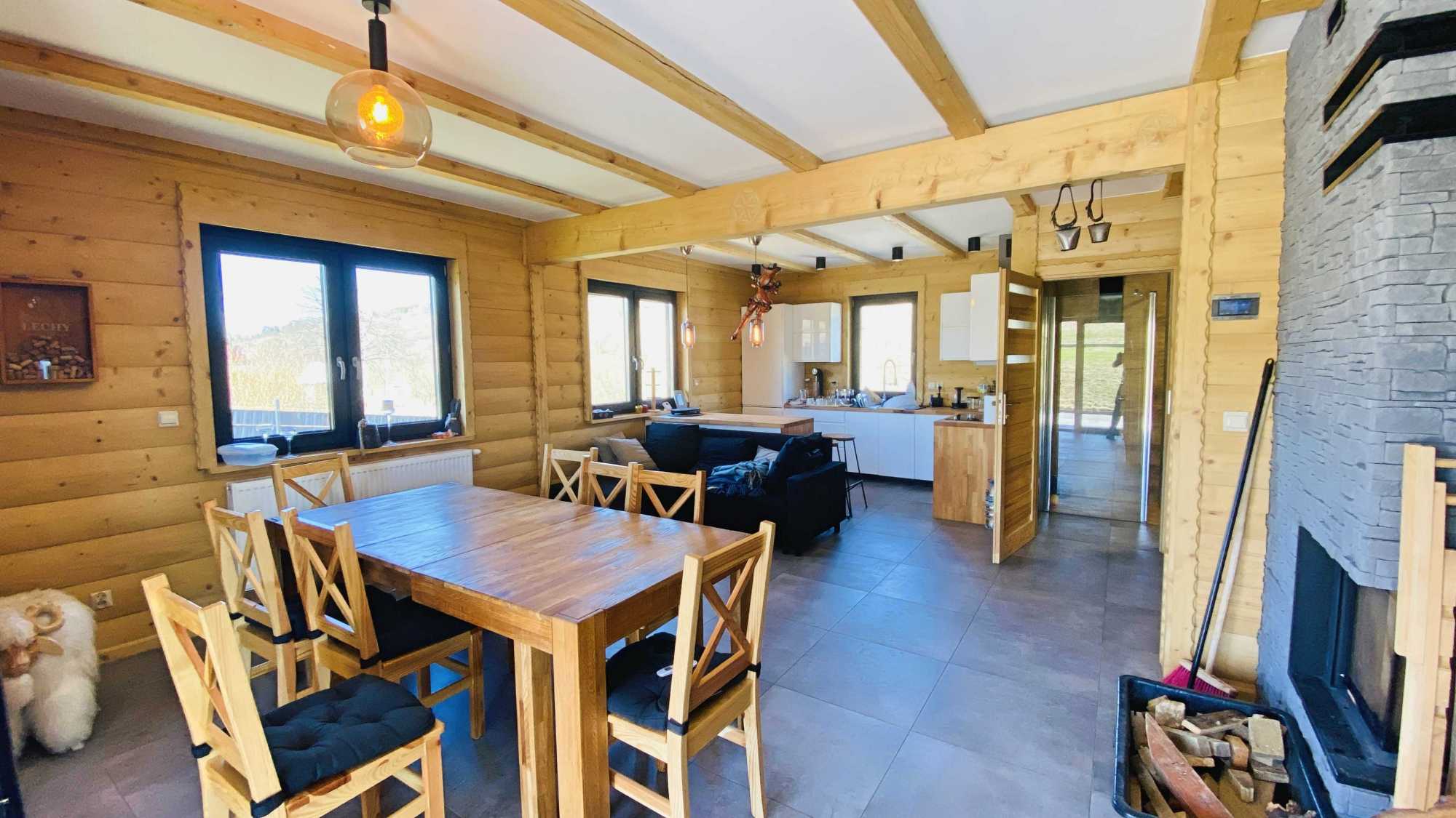 Stylowy kominek w salonie domu z bali w Trybszu