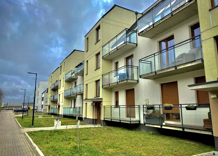 Dom szeregowy z balkonem i trawnikiem wzdłuż chodnika na wrocławskich Maślicach