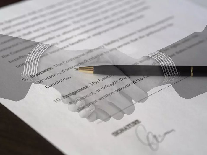 Półprzezroczysty widok uścisku dłoni na zdjęciu podpisanej umowy, na której leży czarny długopis