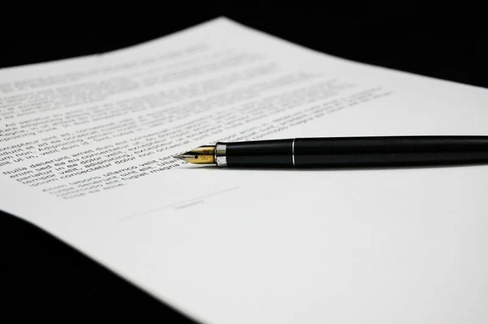 Czarne pióro wieczne ze złotą stalówką leży na dokumencie z wydrukowaną umową