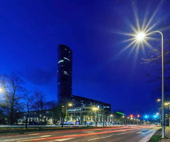 Widok wieżowca Sky Tower od ulicy Powstańców Śląskich we Wrocławiu. Zdjęcie robione porą nocną.